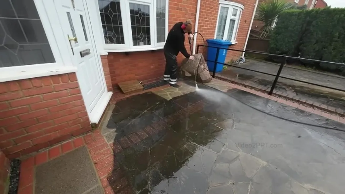 Technician pressure washing a flagstone patio at a property entrance in Jacksonville, Florida