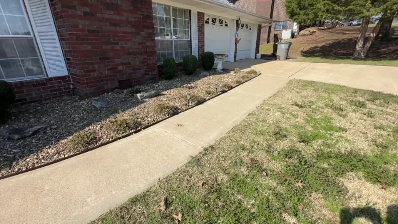 The same concrete walkway cleaned to an even light gray finish after pressure washing