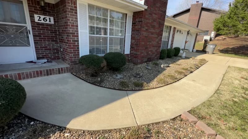 The same curved concrete path cleaned back to bare concrete after pressure washing