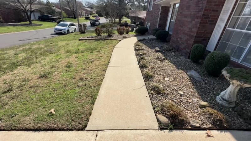The same long concrete walkway after pressure washing, clean from edge to edge