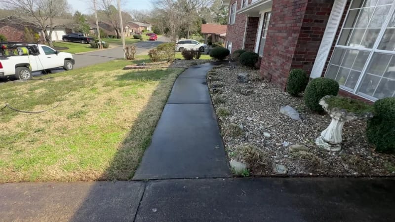Concrete walkway darkened by heavy surface staining before cleaning