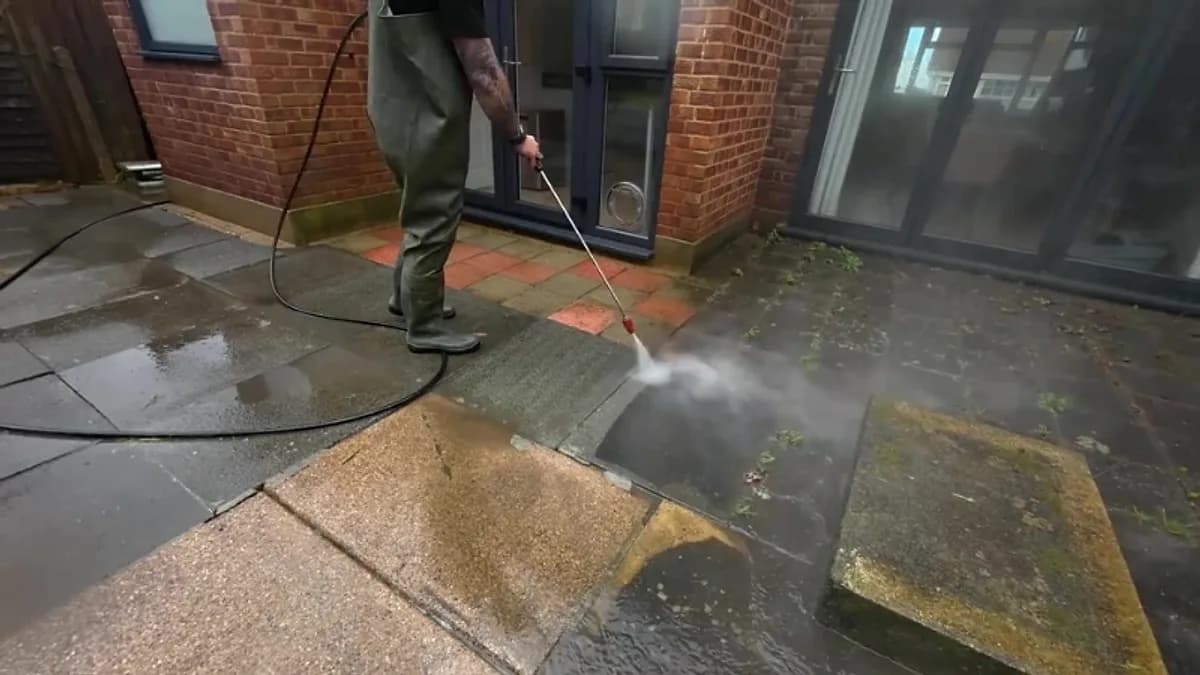 Pressure washing paved flooring outside a glass-fronted commercial building in Jacksonville, Florida