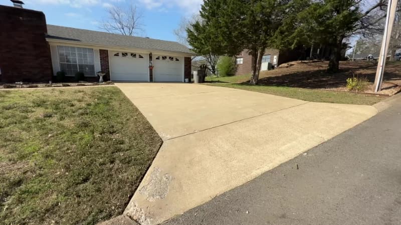 Freshly cleaned concrete driveway leading to a two-car garage at a Jacksonville, Florida home