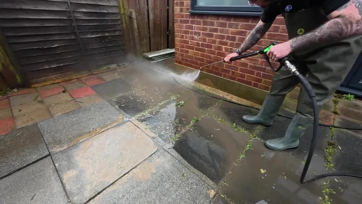 Technician soft washing the brick wall of a Jacksonville home with a low-pressure spray