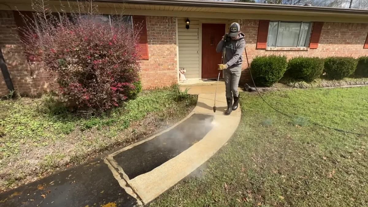 Technician pressure washing the entry walkway of a brick home in Jacksonville, Florida